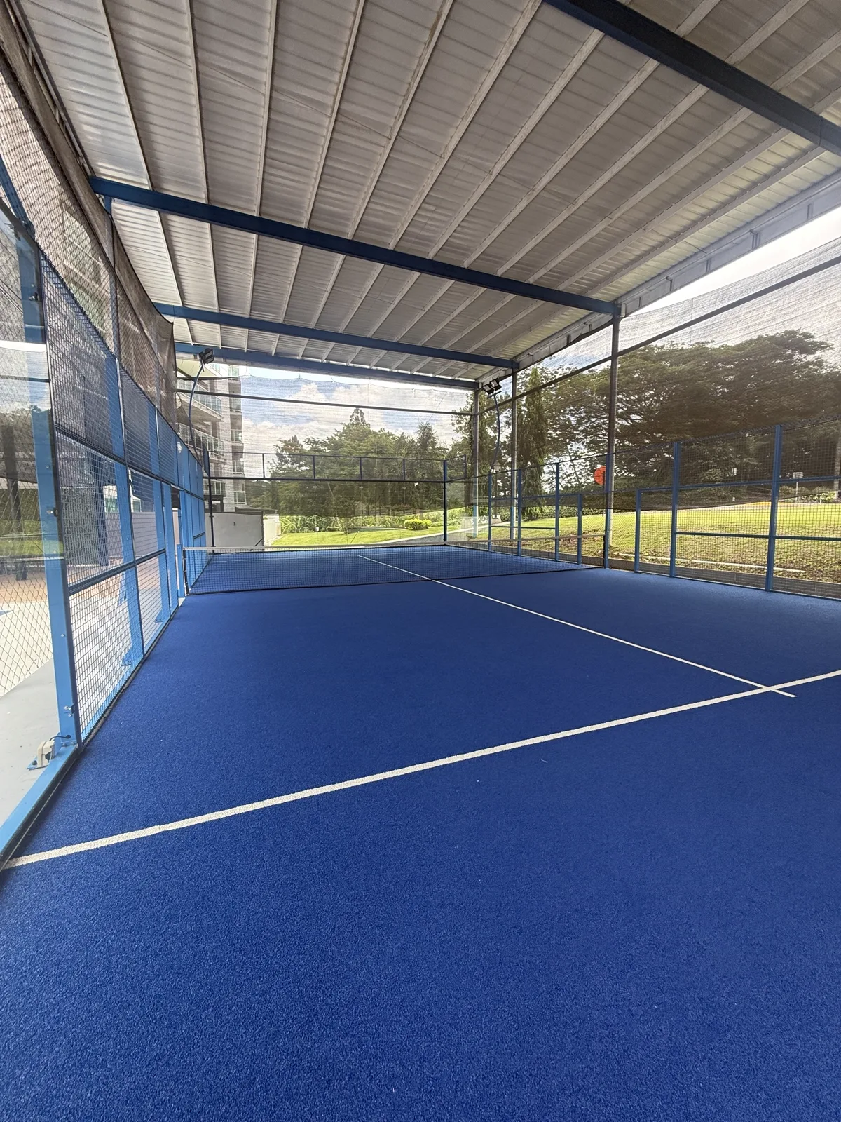 Cancha de pádel techada e iluminada, vacía