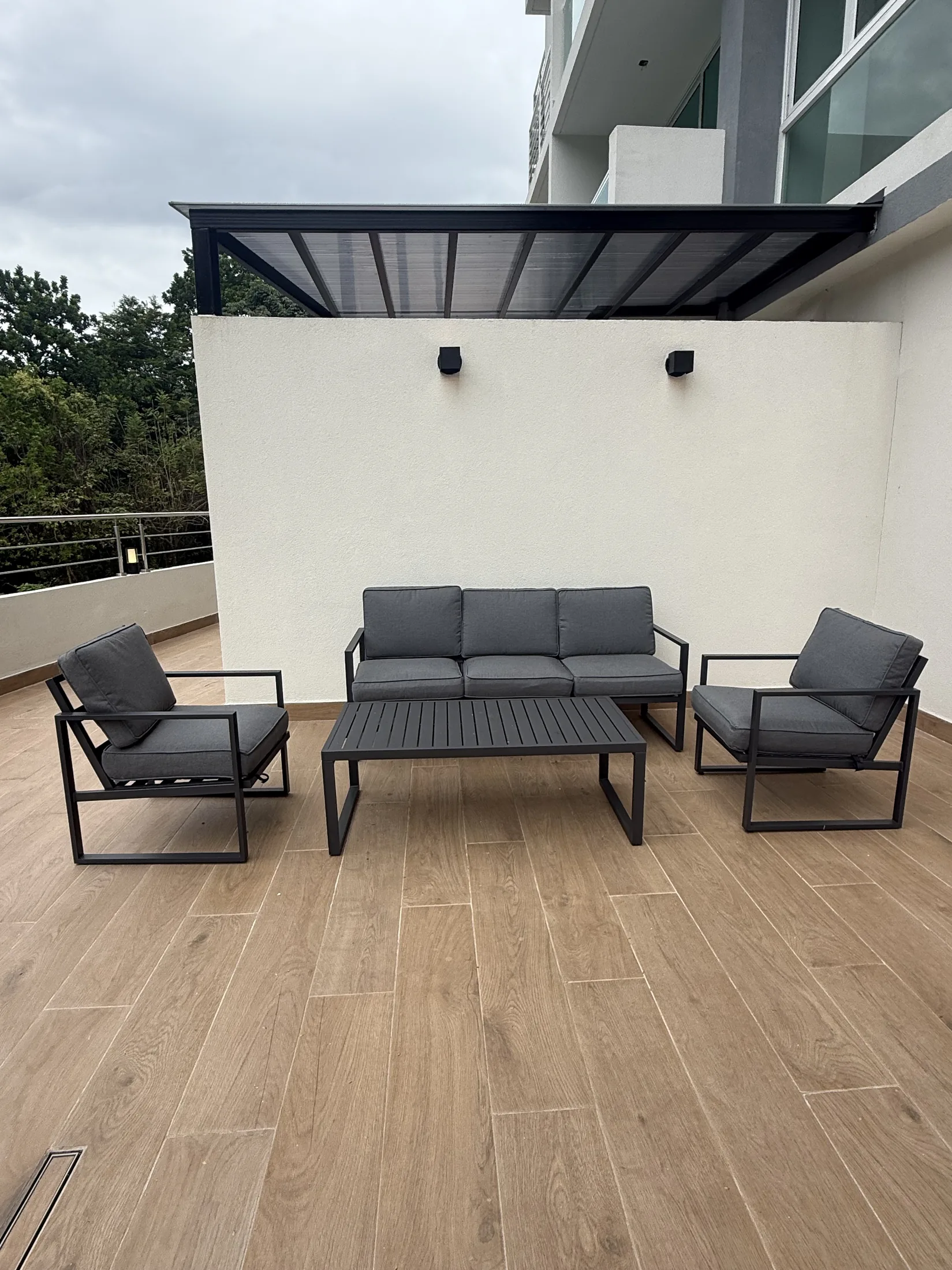 Lounge exterior con sofás frente al bosque